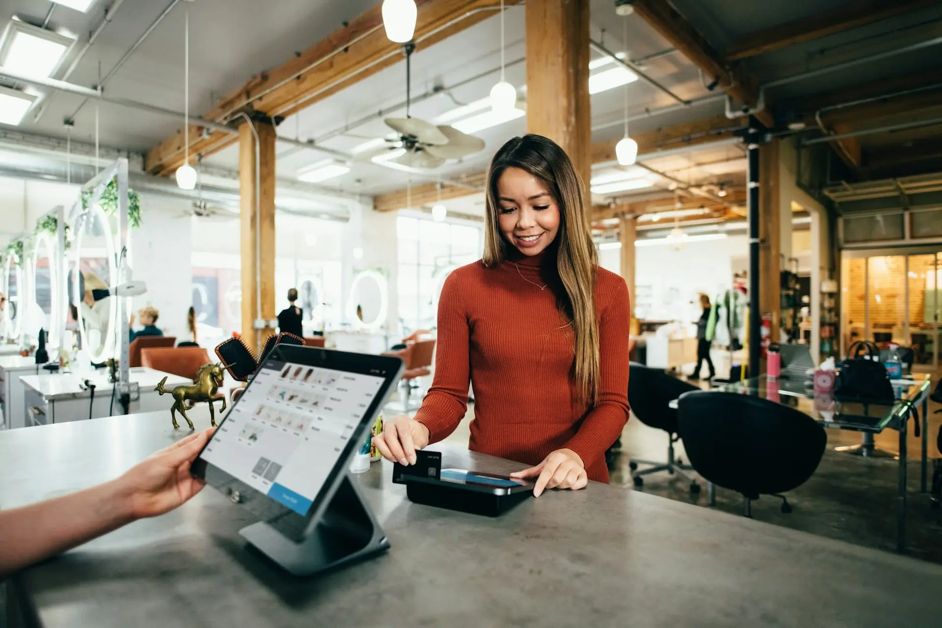 Customer paying by card at a tablet point-of-sale counter in a store