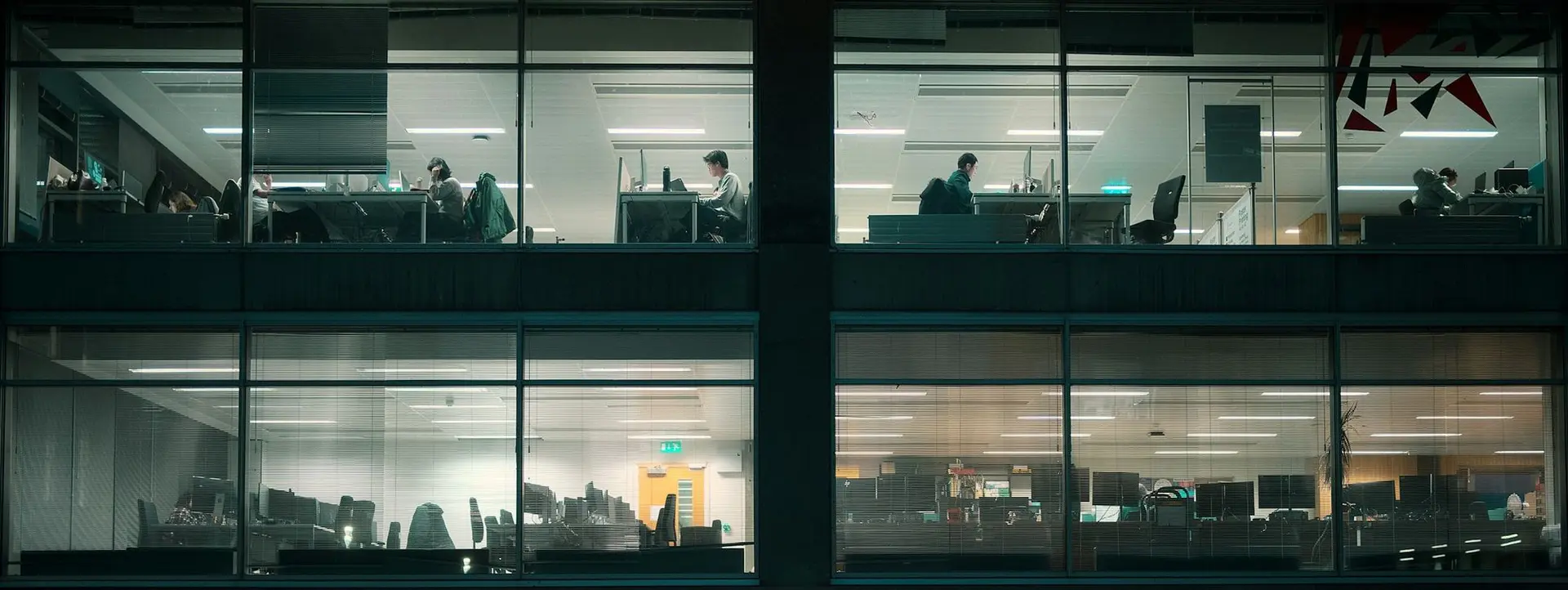 Office floors lit at night, seen from outside